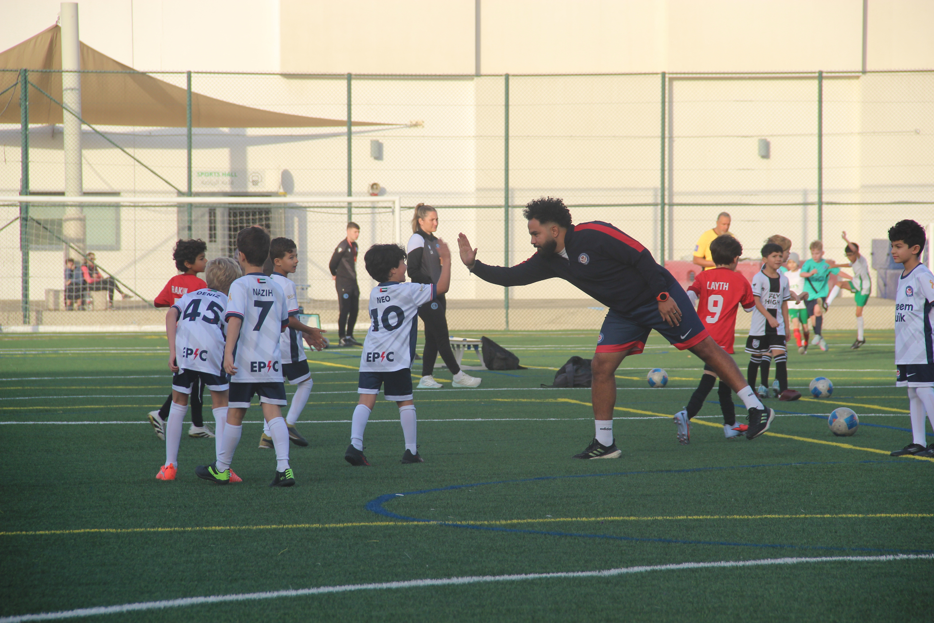 EPIC coach high-fiving young players during a training session